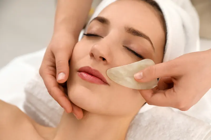 Stone massage on a woman's face