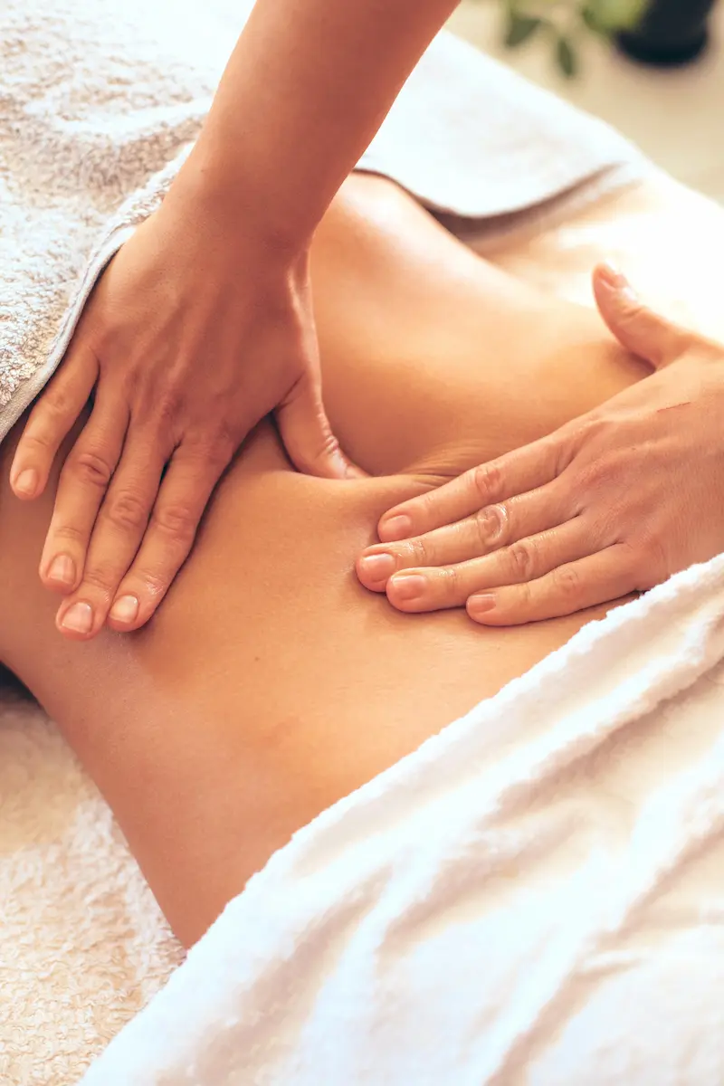 Two hands massaging a back