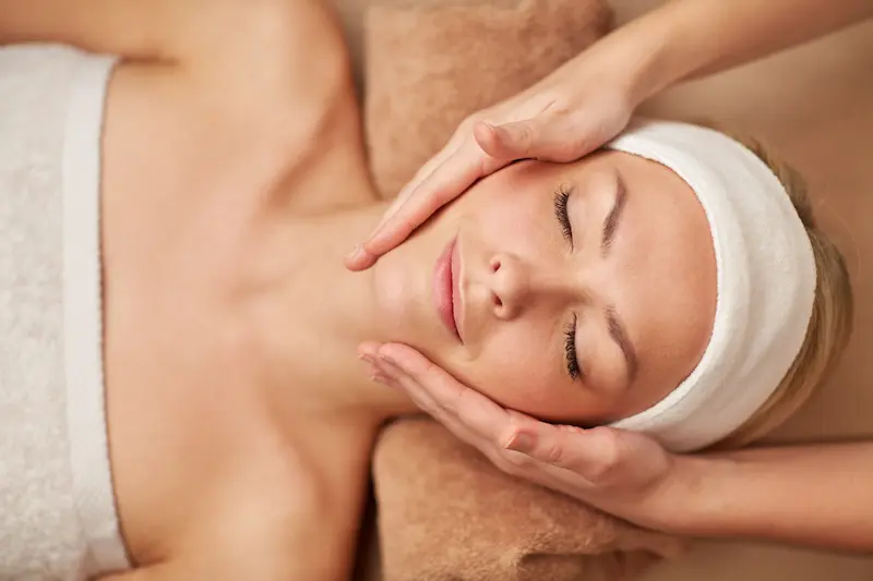 Woman on a spa table receiving a facial massage
