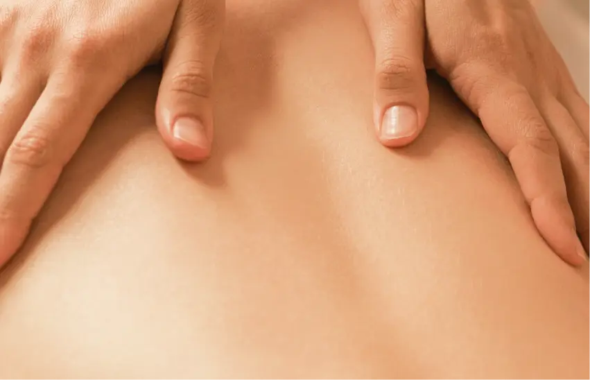 A back being rubbed by hands