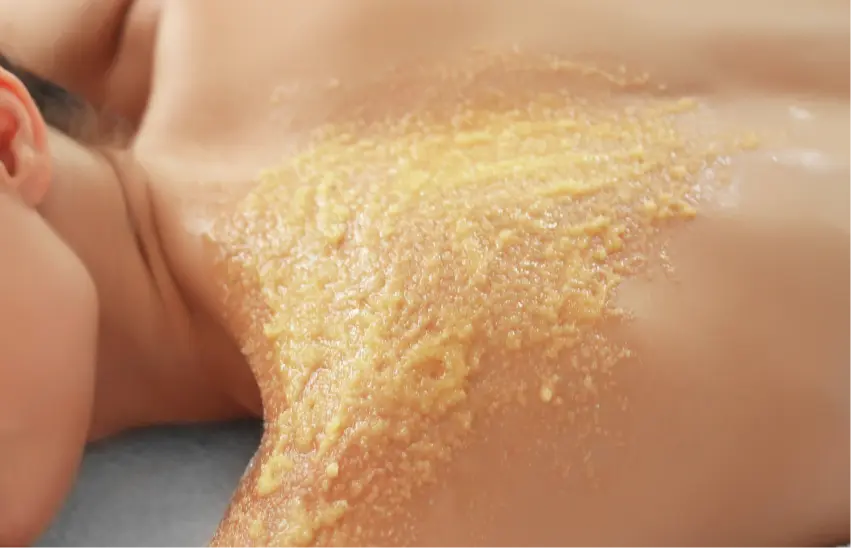 Salt scrub applied to a person's back