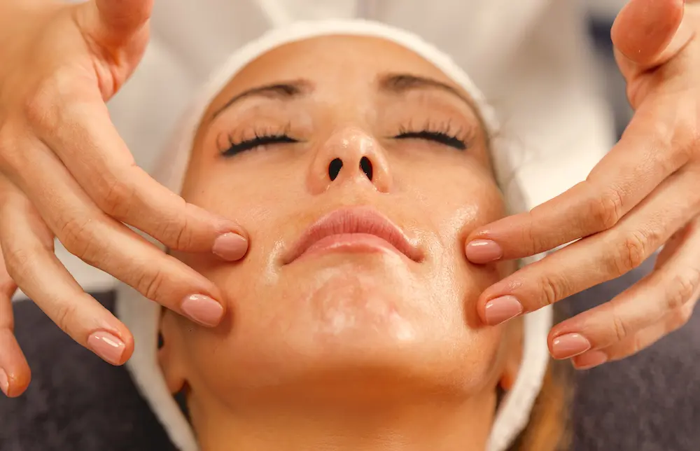 Fingers massaging woman's face